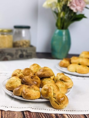 Easter cookies served on a white plate with flowers and jars in the background.