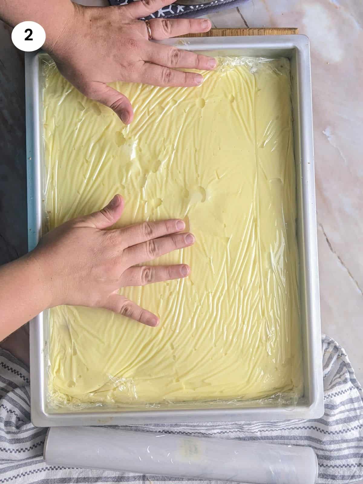 Adding cling film on top of the custard.