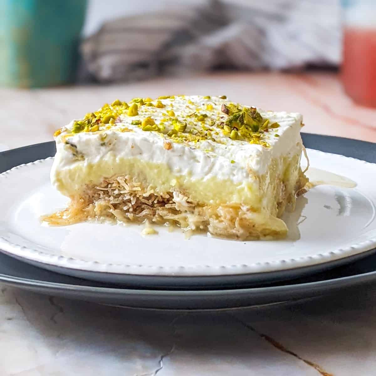 A slice of ekmek kataifi served on a white plate.
