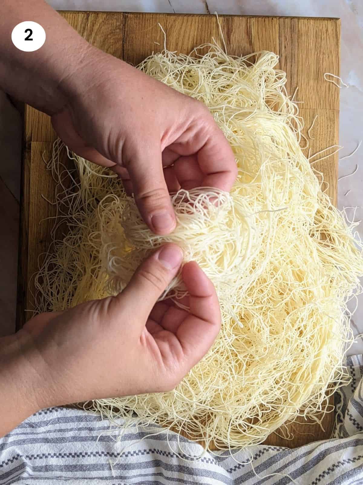 Pulling the kataifi dough apart until its triple the size and more airy and light.