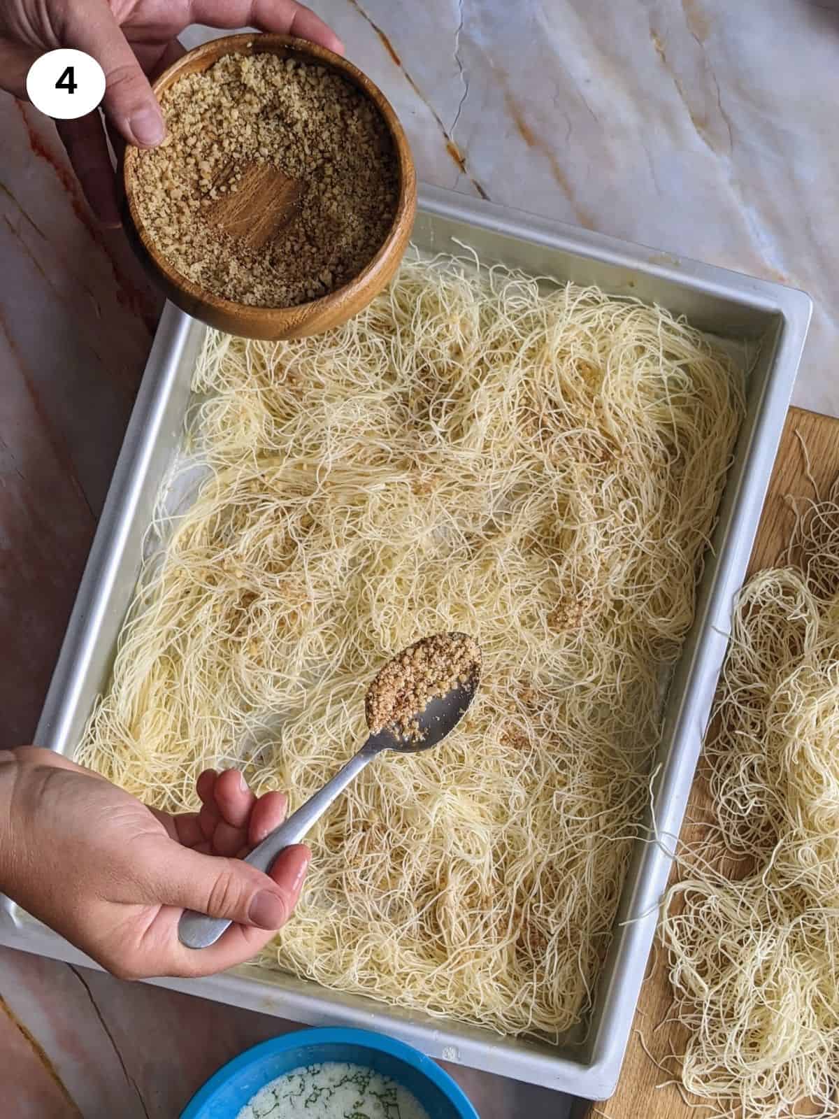 Spreading the chopped walnuts on top of the kataifi.