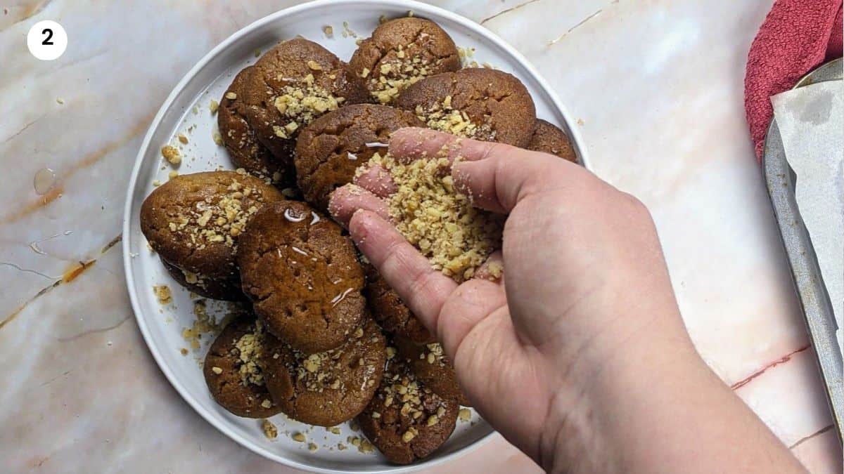 Adding honey and chopped walnuts on top of each cookie Adding honey and chopped walnuts on top of each cookie.