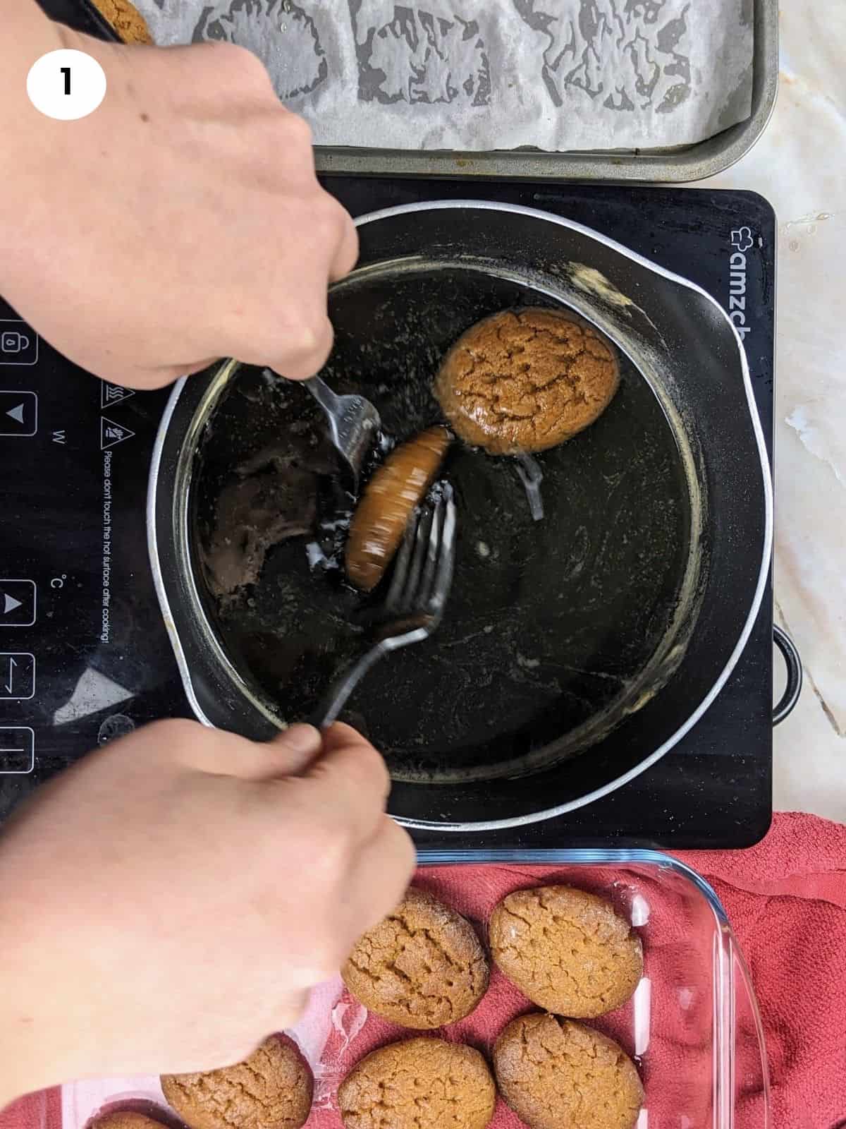 Dipping the melomakarona cookies in syrup.