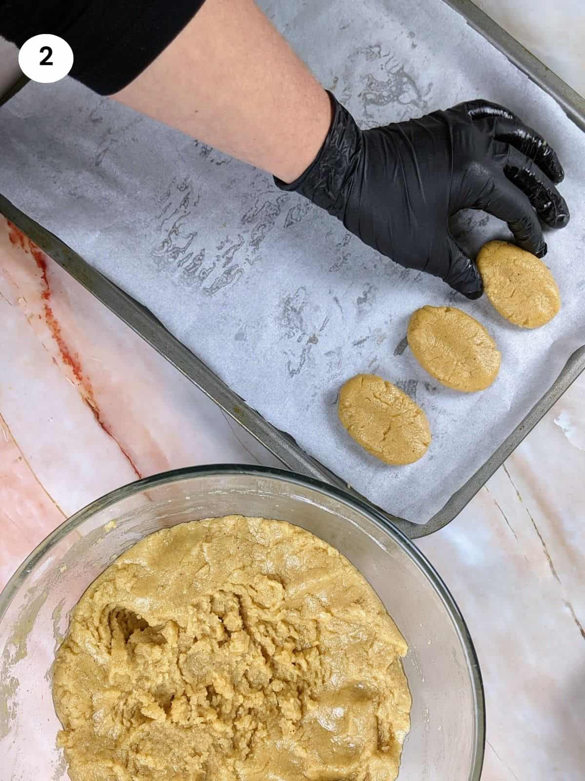 Placing the honey cookie on a lined baking tray.