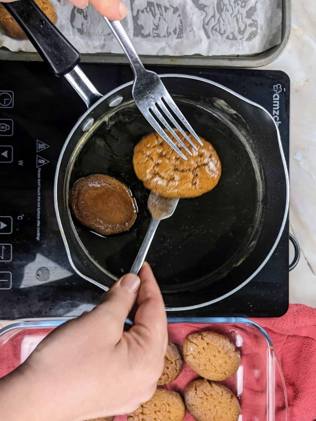 Taking the cookies out of the syrup.