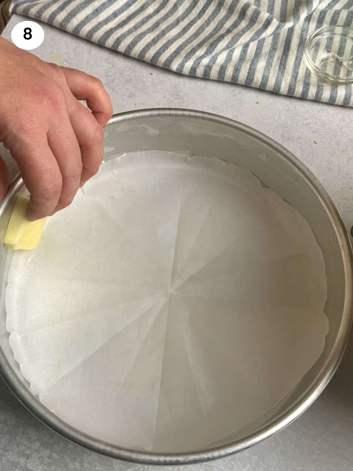 Adding parchment paper to the bottom of the tin.