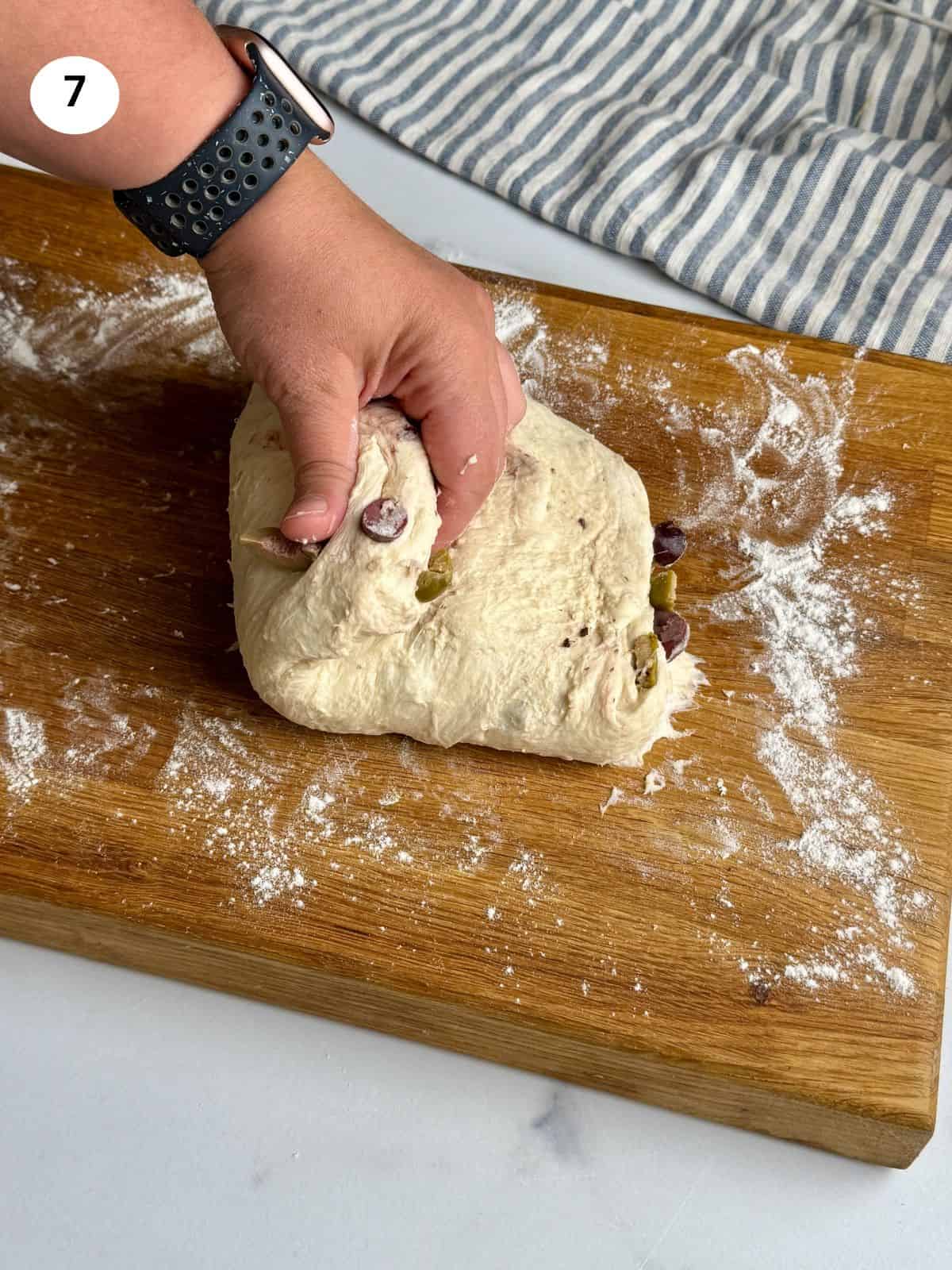 Stretching and folding the dough.