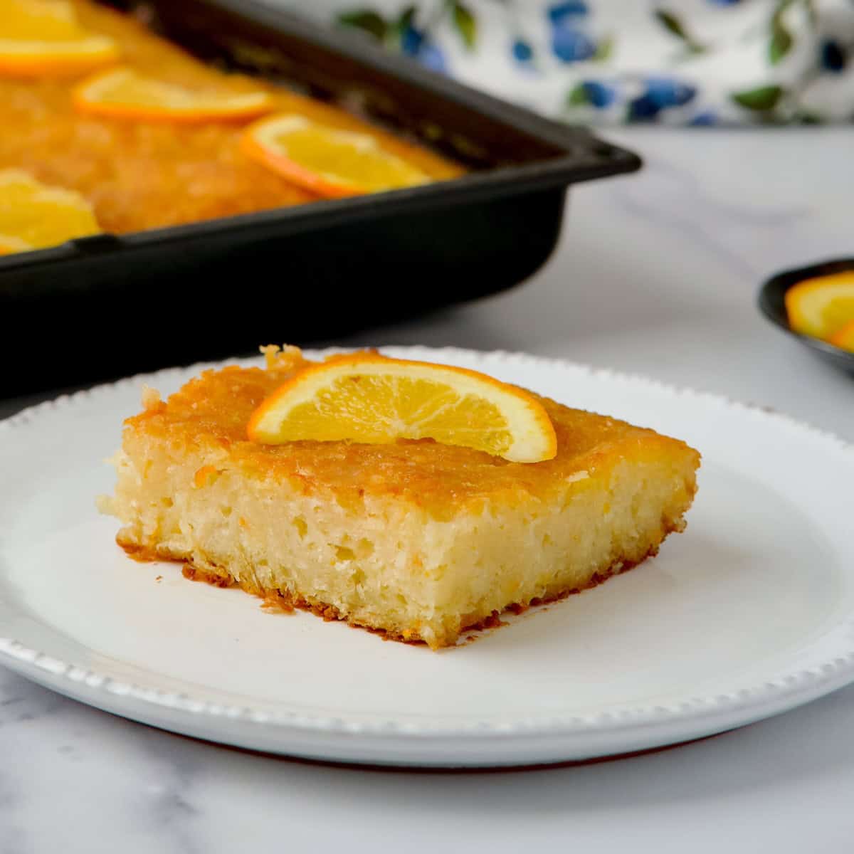 A slice of Greek orange cake served on a white plate.