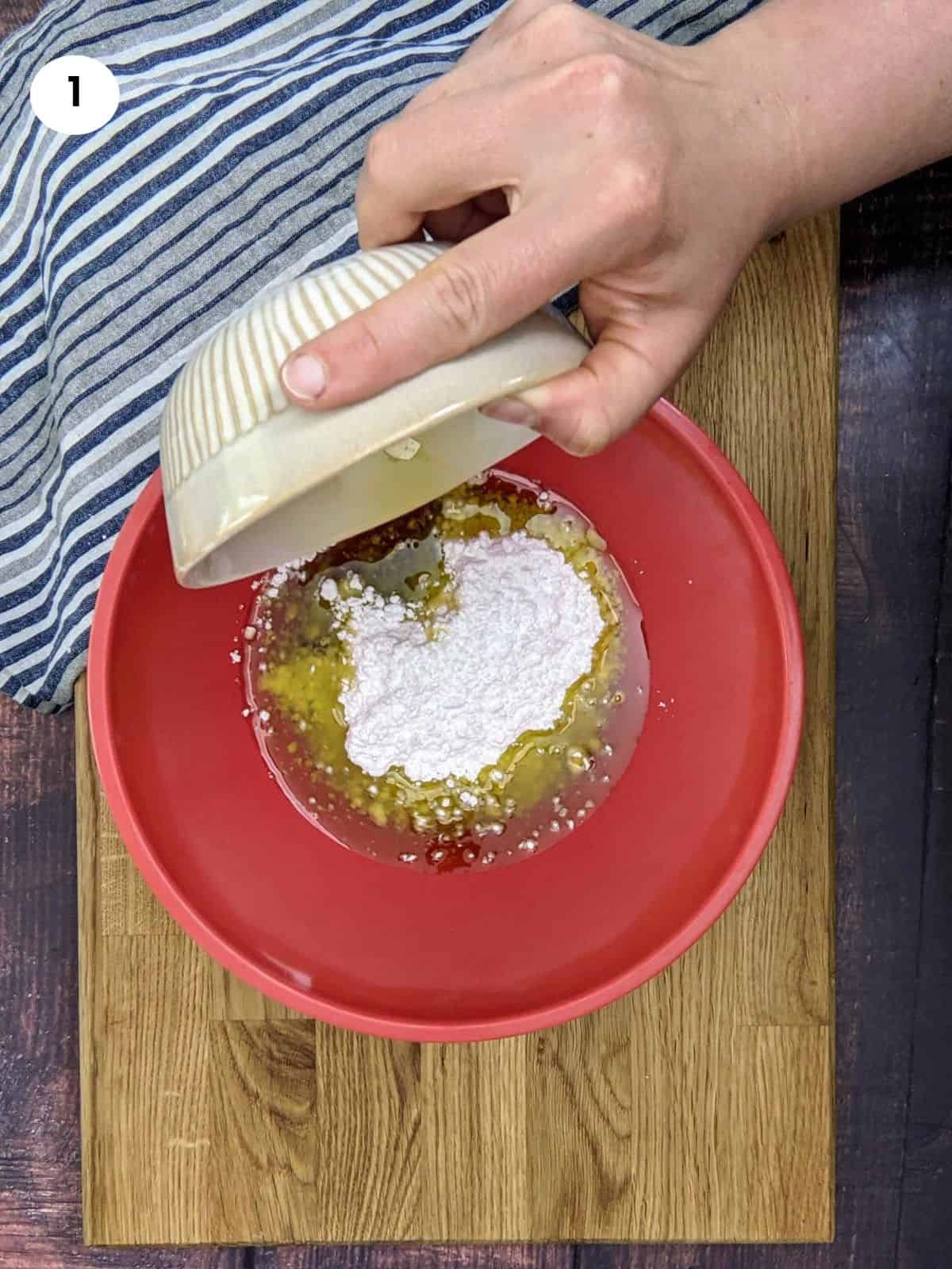 Adding oil to powdered sugar for greek orange cookies.