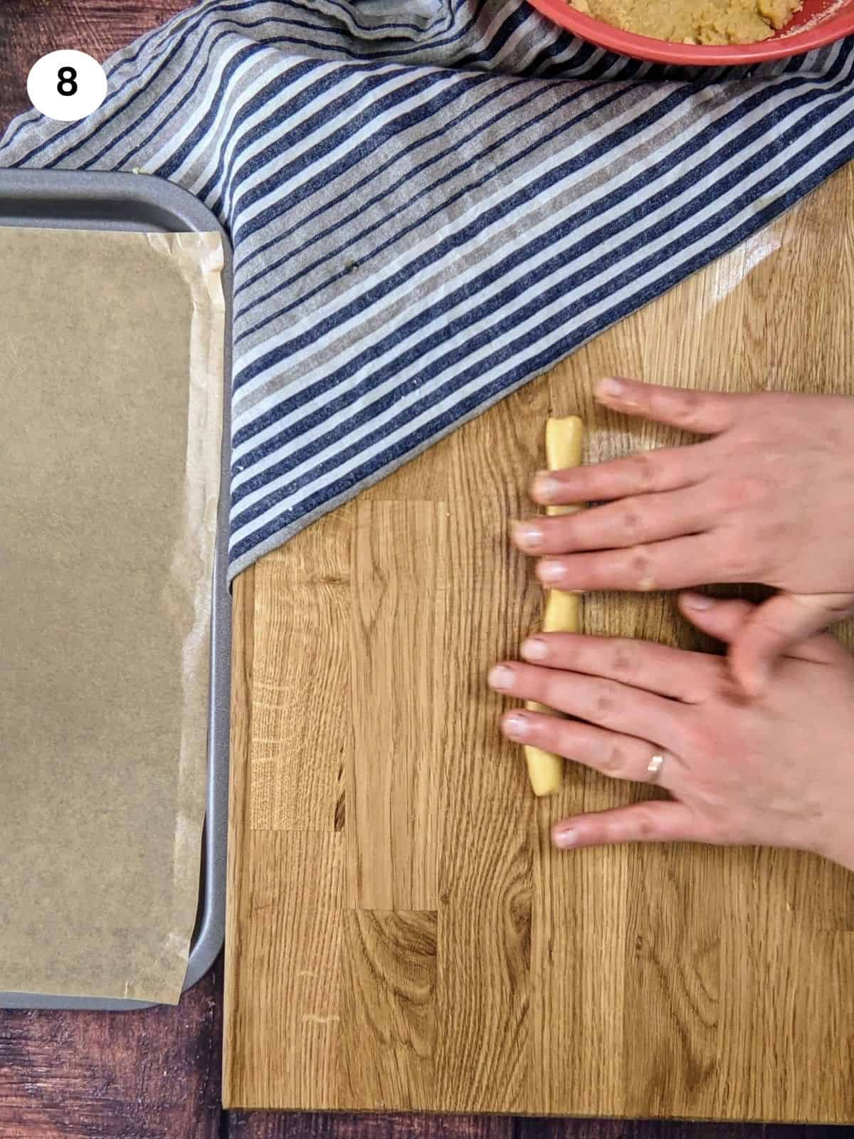 Rolling the dough to a stick for greek orange cookies.