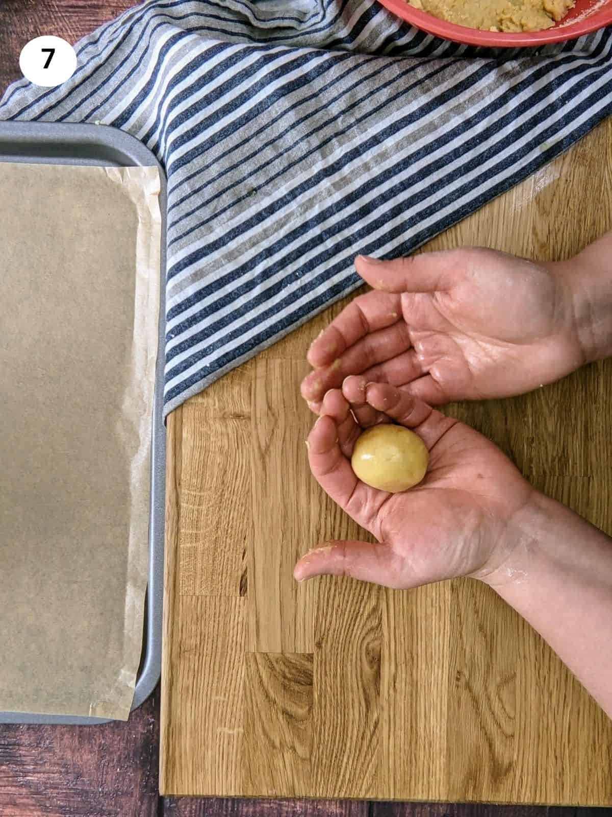Shaping a dough ball for greek orange cookies.