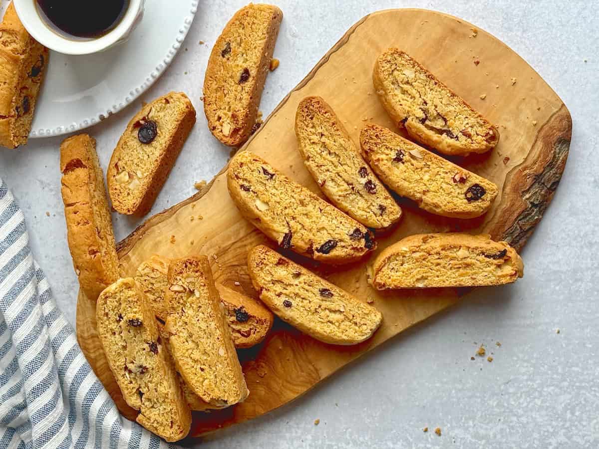 Greek biscotti paximadia on a wooden board with coffee next to them.