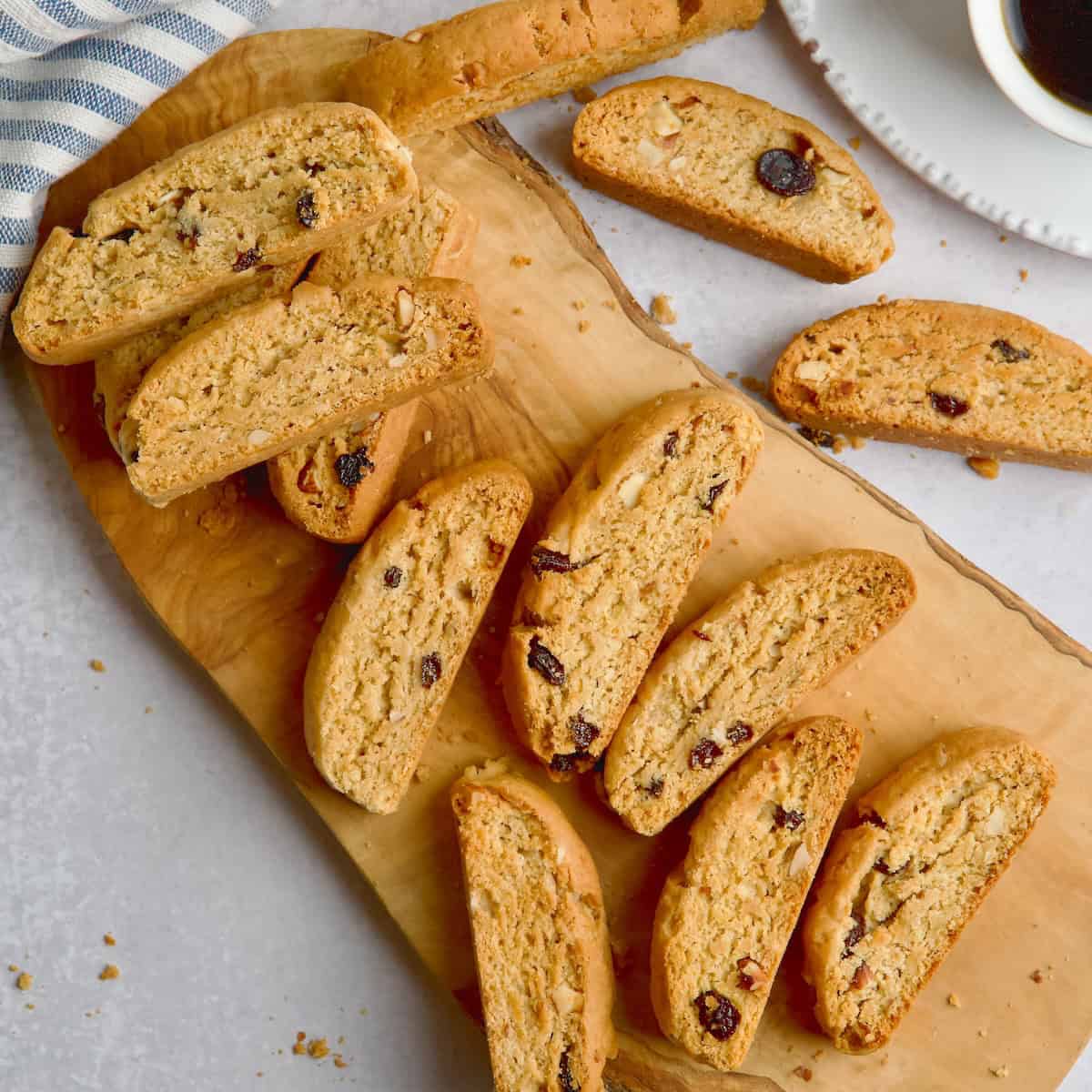 Greek biscotti paximadia on a wooden board with coffee next to them.