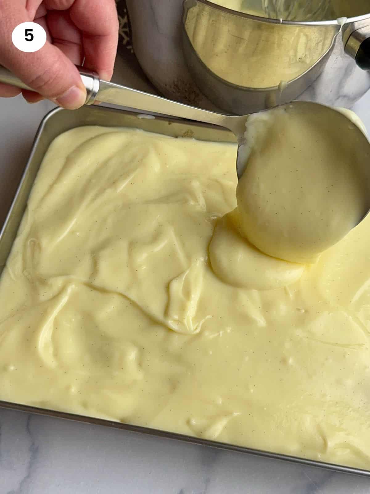 Spreading the custard on top of the semolina base.