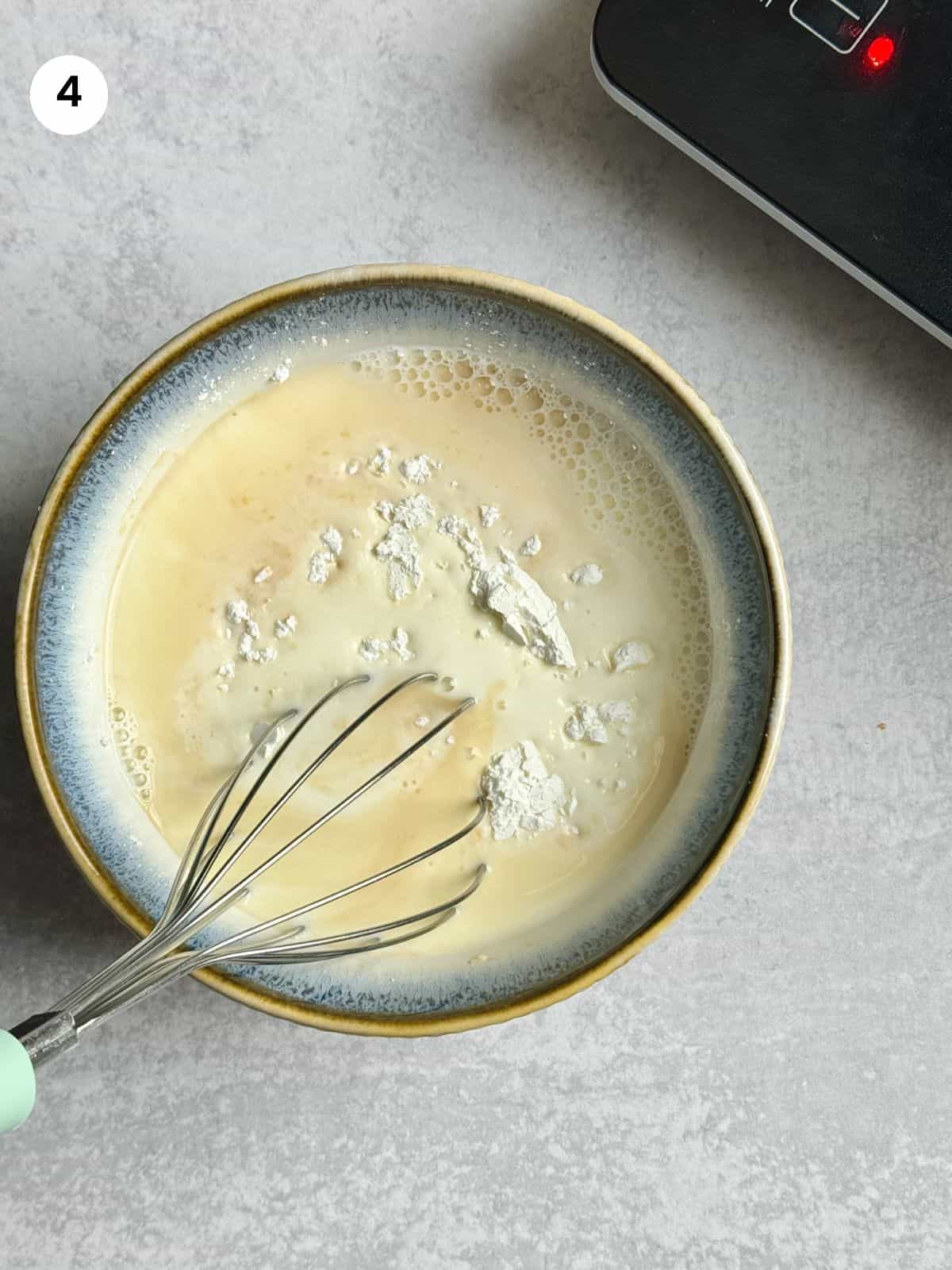 Mixing the cornstarch, vanilla and remaining milk in a bowl.