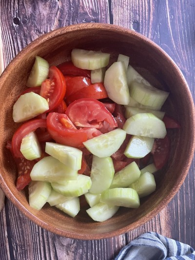 Chopped tomatoes and cucumber in the salad bowl.