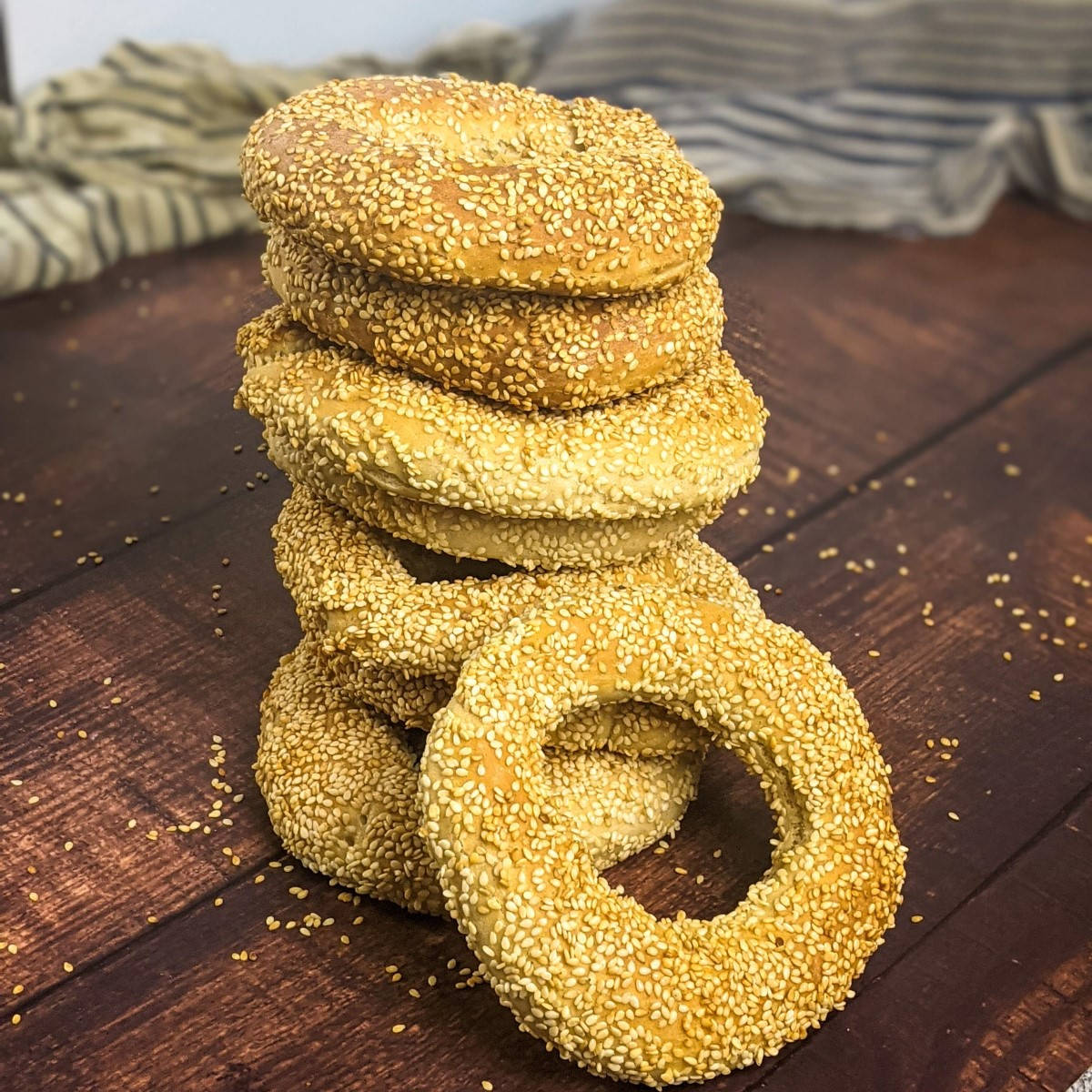 Sesame seed bagels one on top of the other and one on the side.