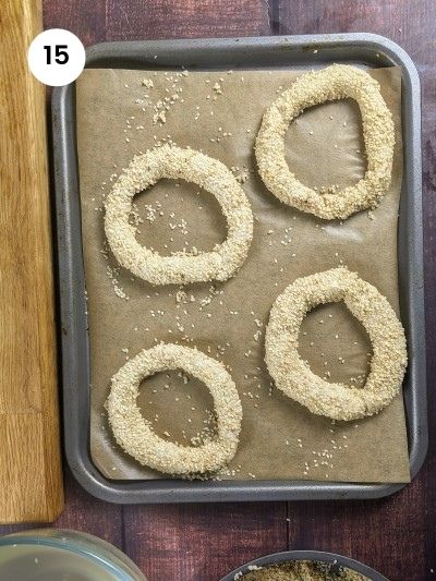 Four greek koulouria placed on a lined baking tray.