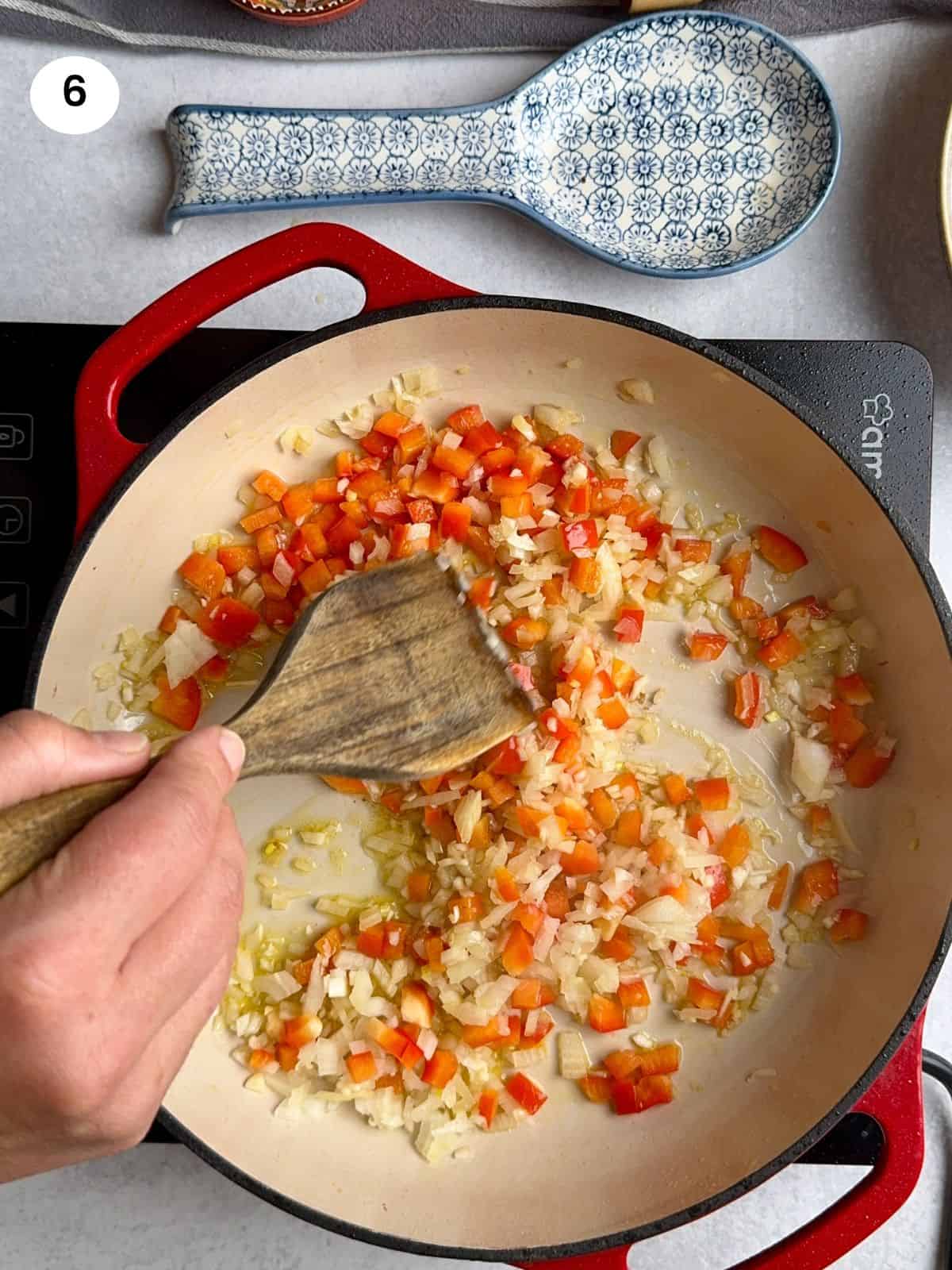 Cooking the onion and pepper in the pan.