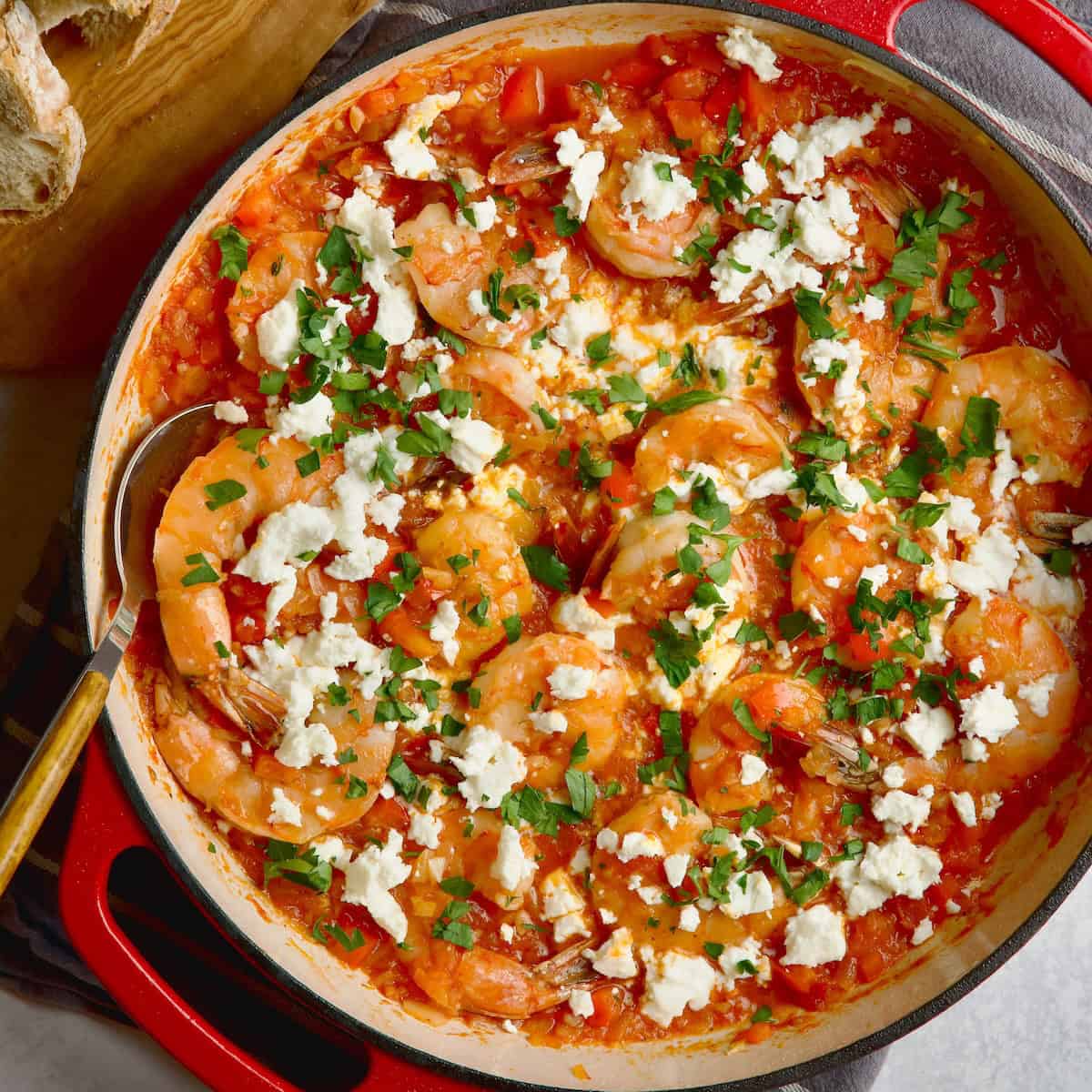 Shrimp cooked in tomato sauce with crumbled feta cheese and chopped fresh parsley on top.