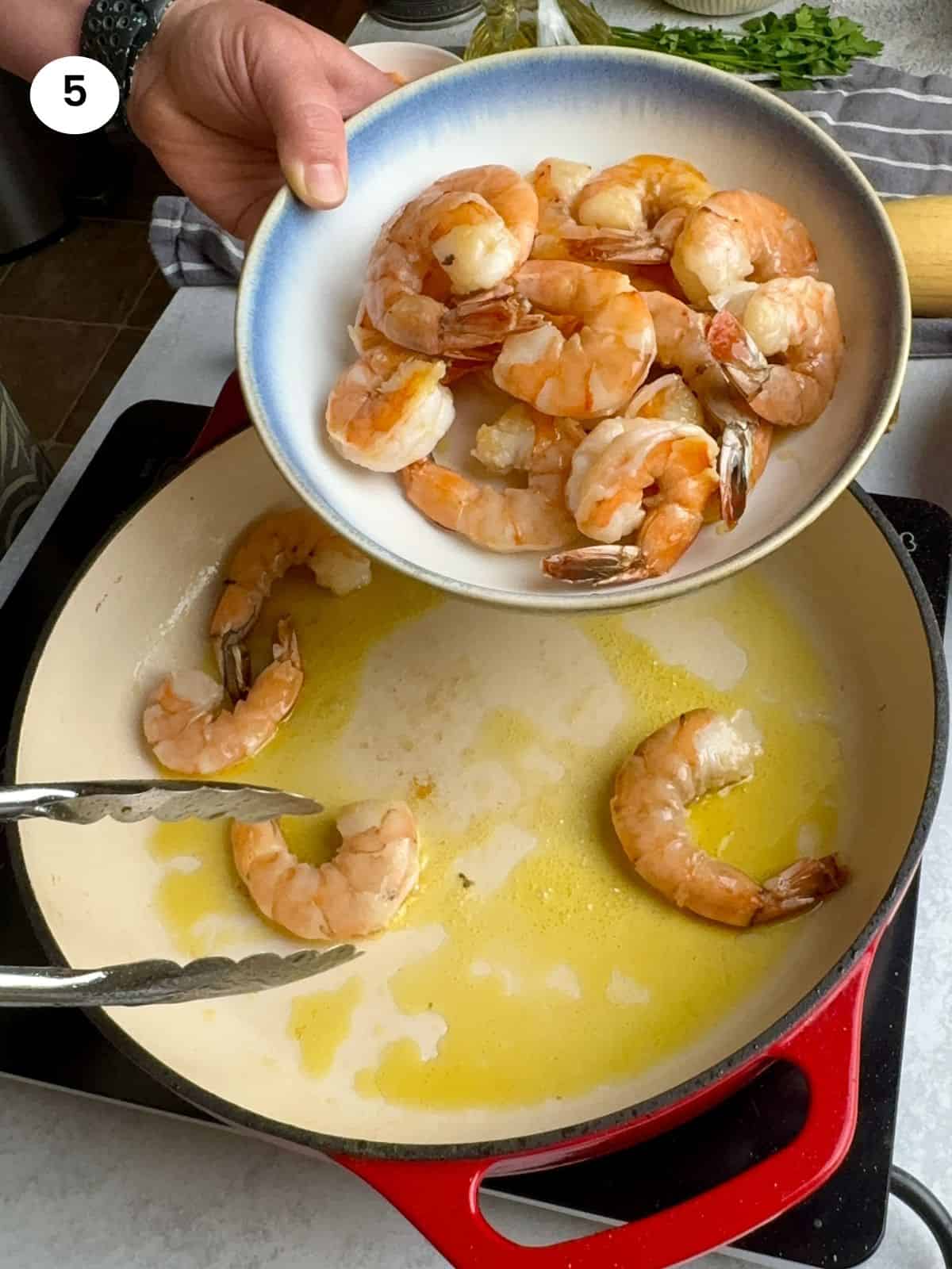 Removing the shrimp from the pan.