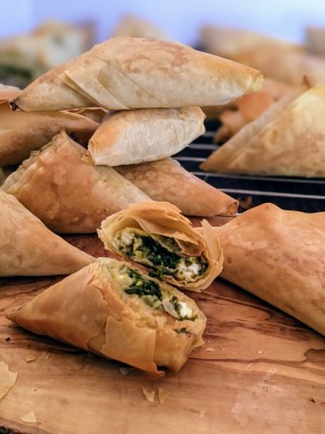 Spinach and feta cheese triangles served on wooden board