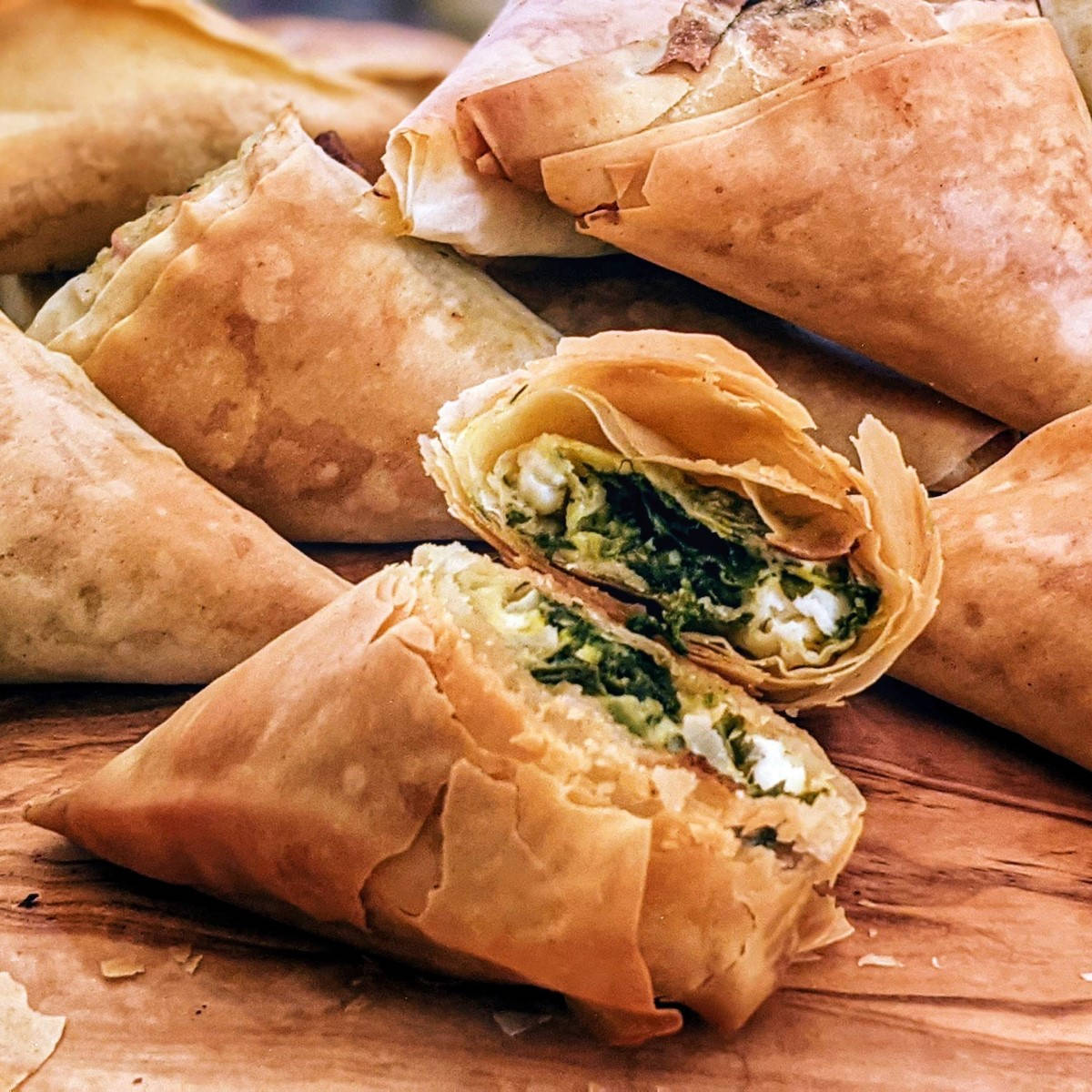 Spinach and feta cheese triangles served on wooden board
