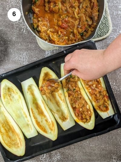 Adding the filling to the eggplants.