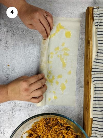 Start rolling phyllo pastry into a long roll.