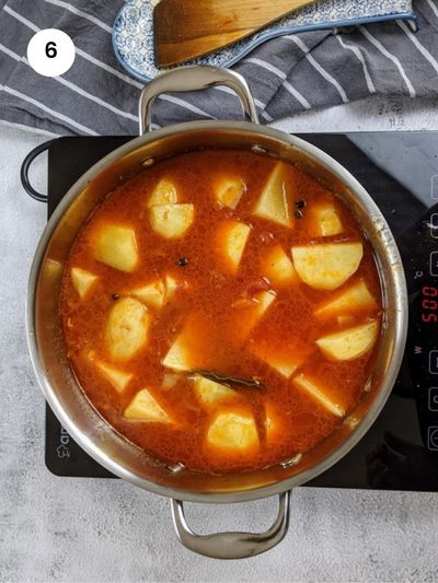 Adding the potatoes and water to the pot.