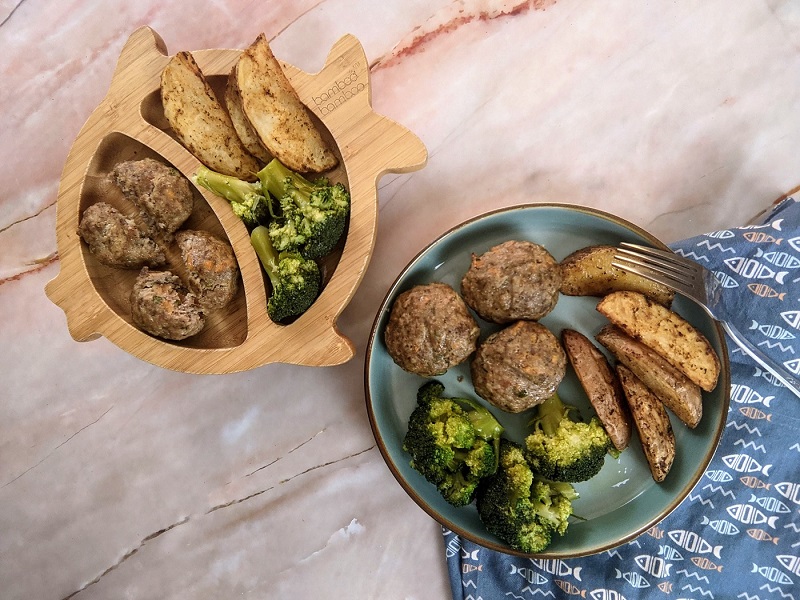 Served greek burgers for adult and child with veggies on the side.