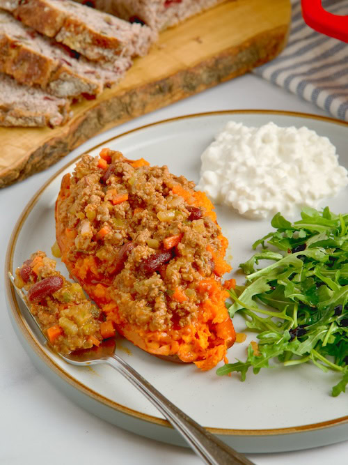 Loaded sweet potato with arugula salad and cottage cheese on the side.