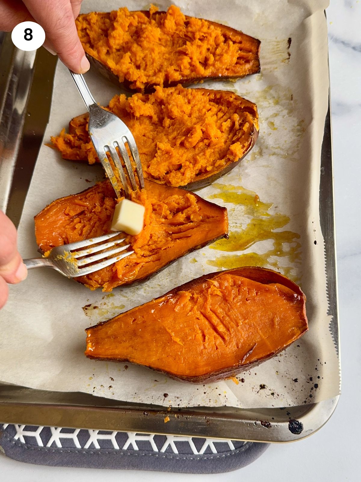 Mashing the flesh of the sweet potatoes with a fork.