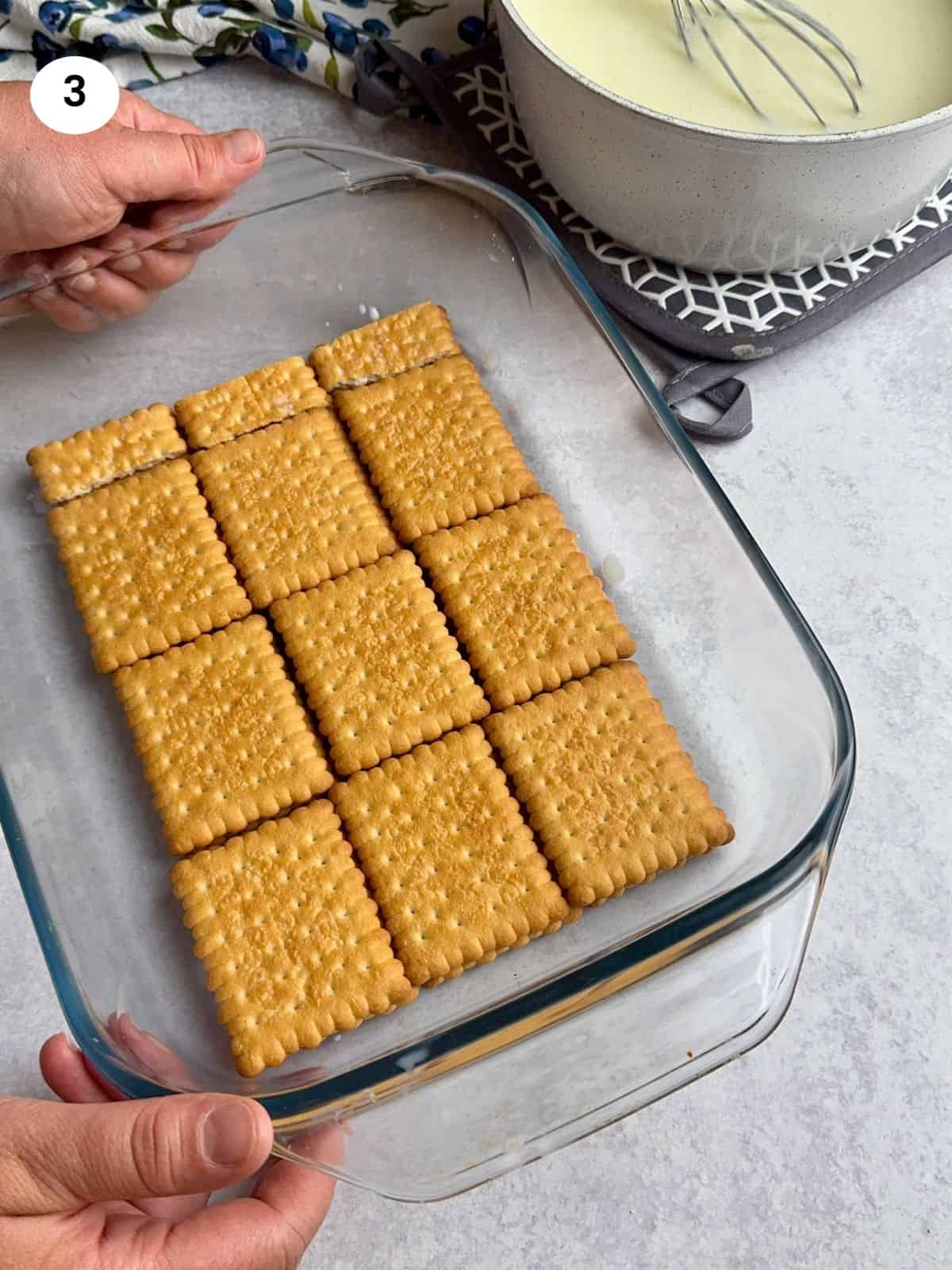 Biscuits layered on the bottom of pyrex tray.