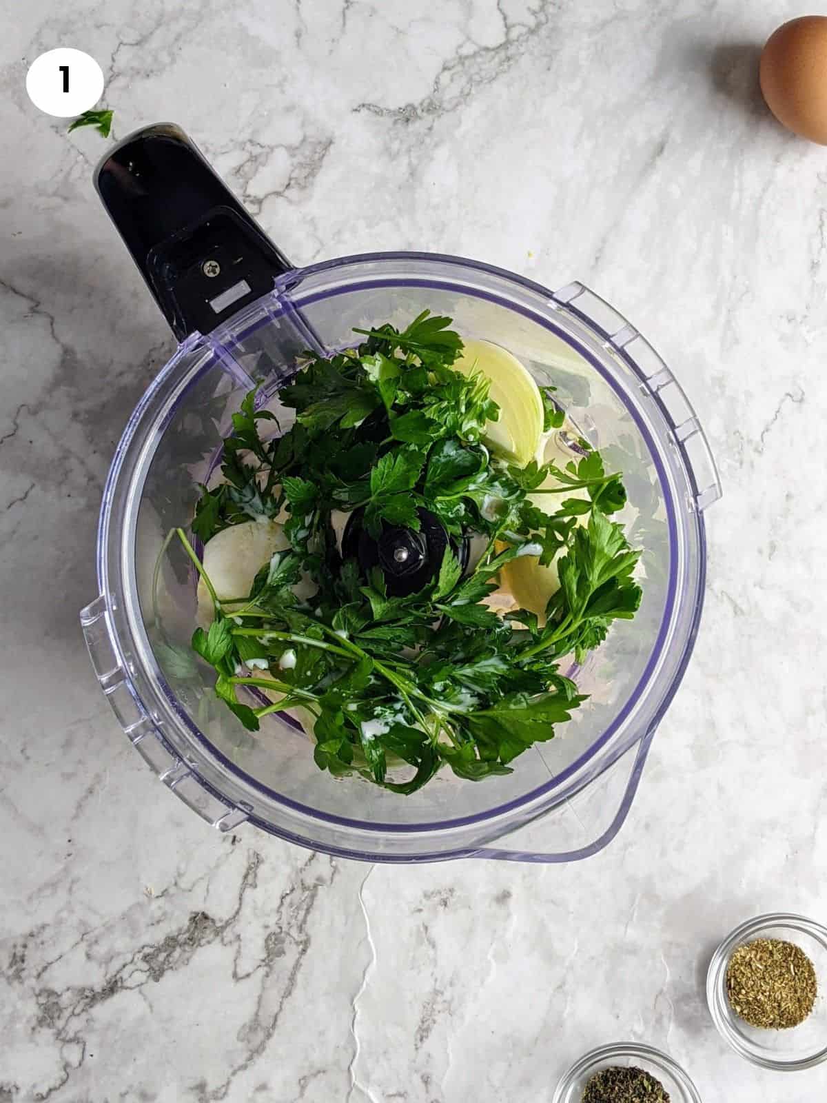 Adding the onion, garlic, parsley and wet ingredients to the food processor.