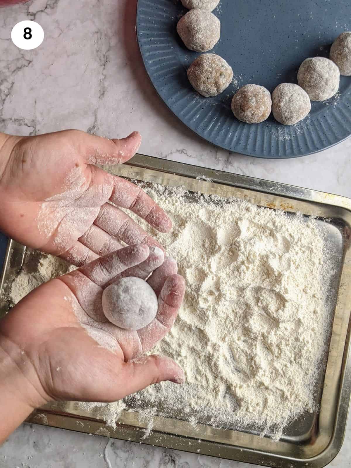 Coating the meatballs with flour.