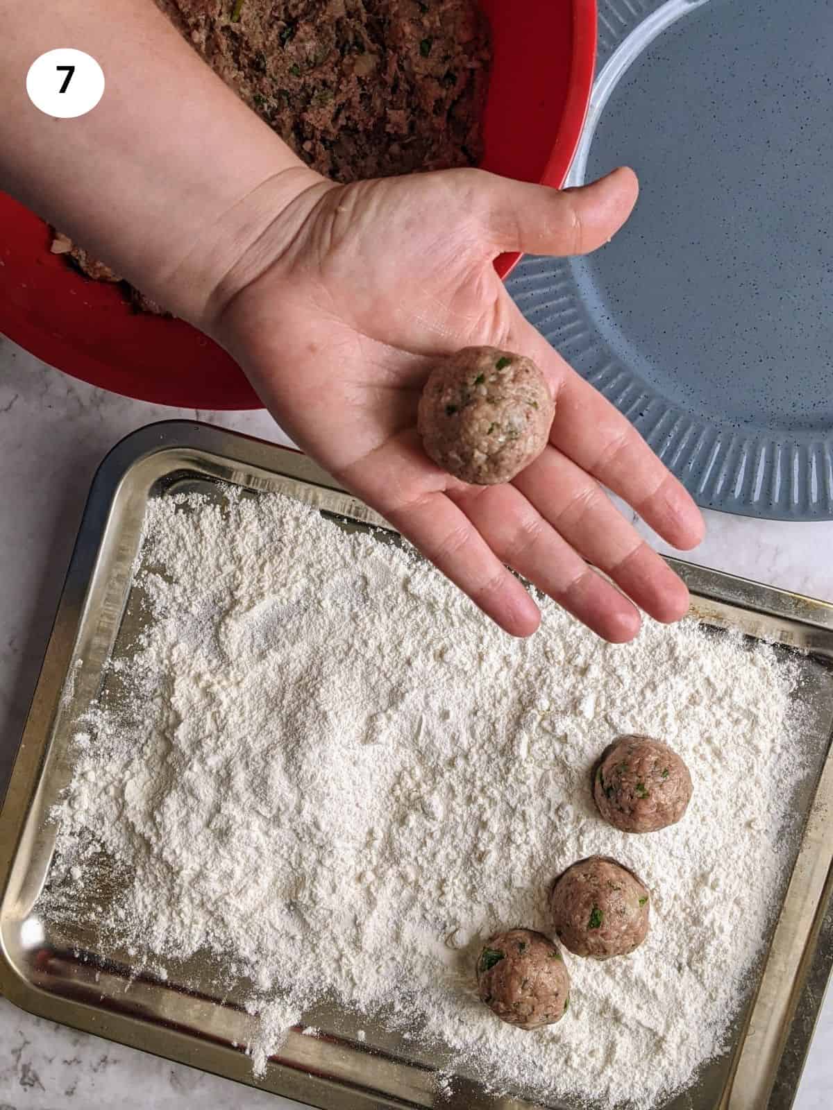 Shaping the meatballs into a round shape.