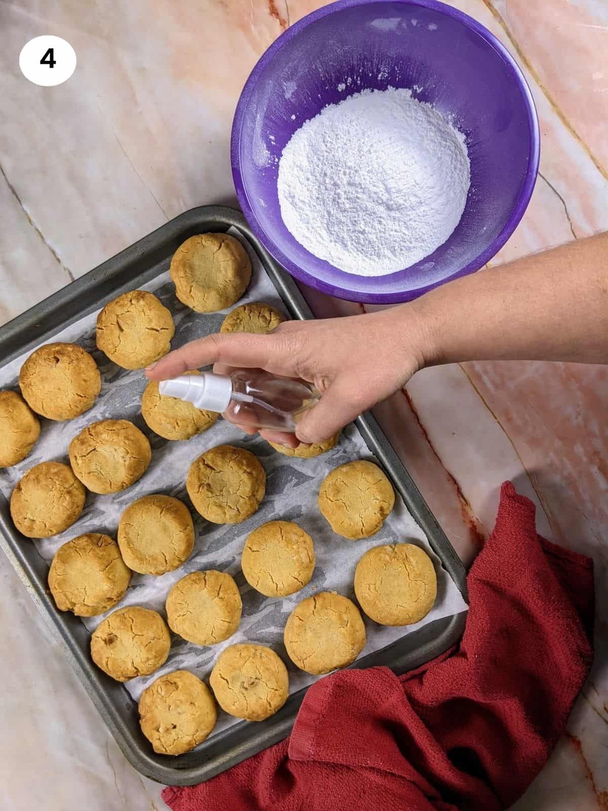 Spraying the greek butter cookies with rose water.