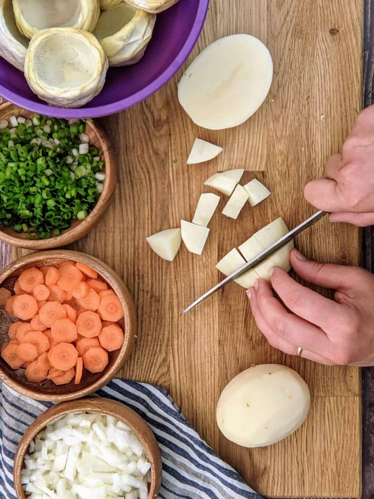 Chopping potatoes in dices for artichoke stew.
