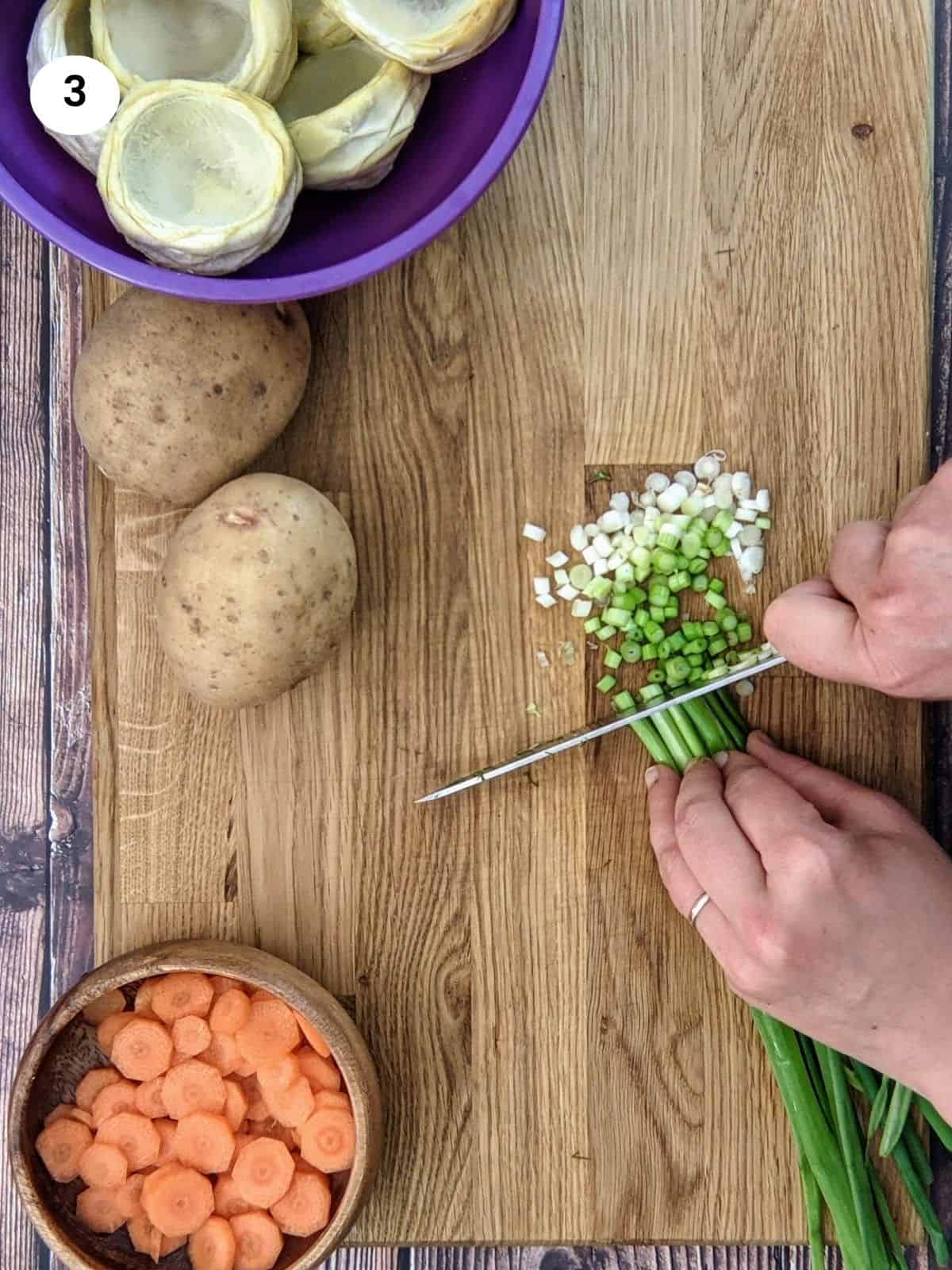 Chopping green onions in slices for artichoke stew.