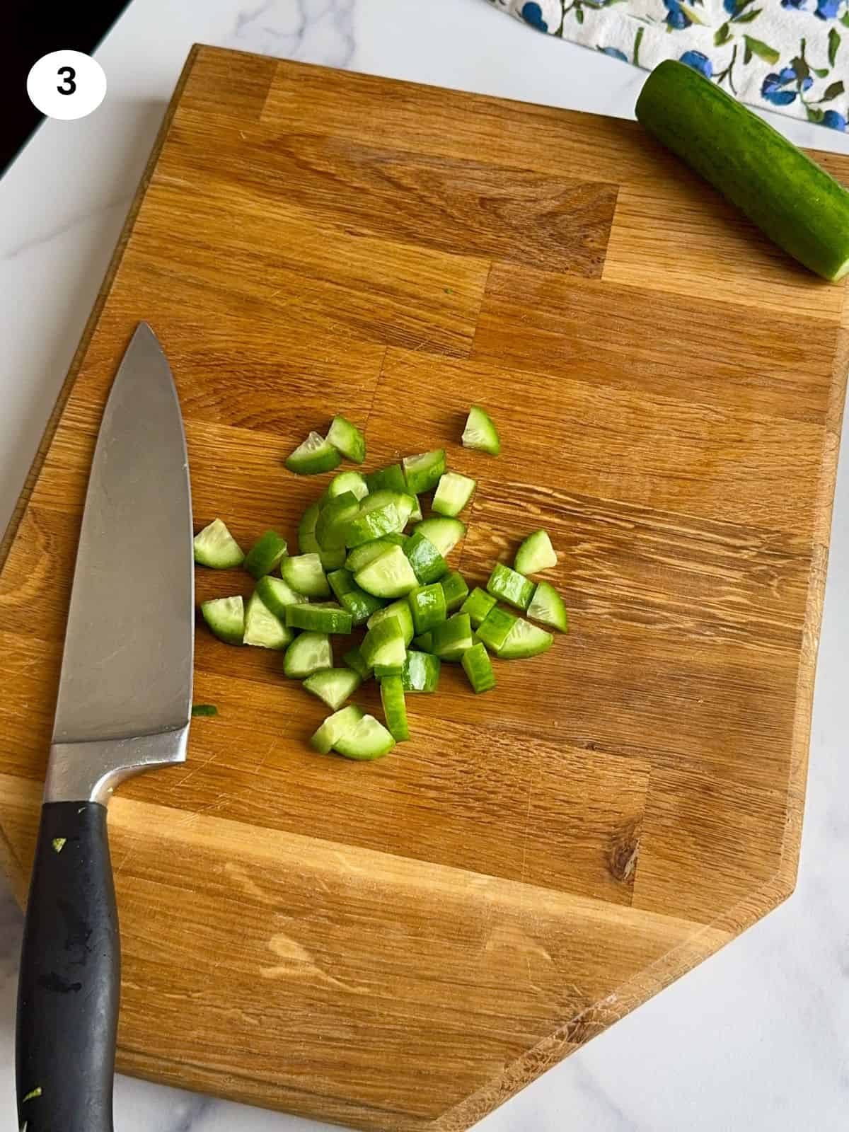Cutting the cucumbers into smaller bits.