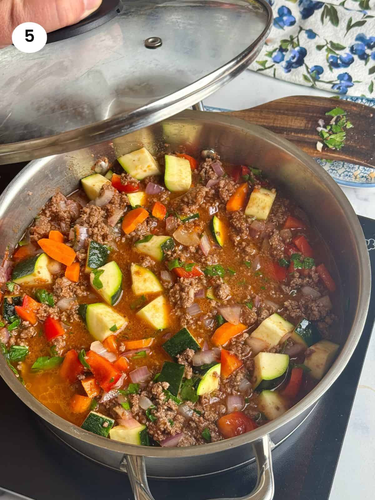 Closing the pot with the lid to simmer.