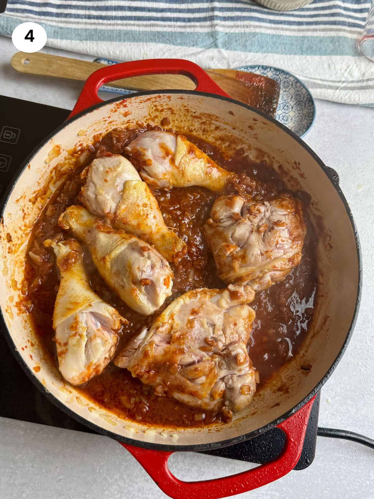 Added the chicken on top of the spices and tomato paste.