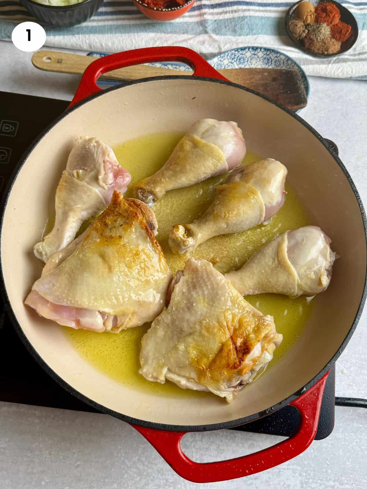 Browning the chicken pieces on both sides.