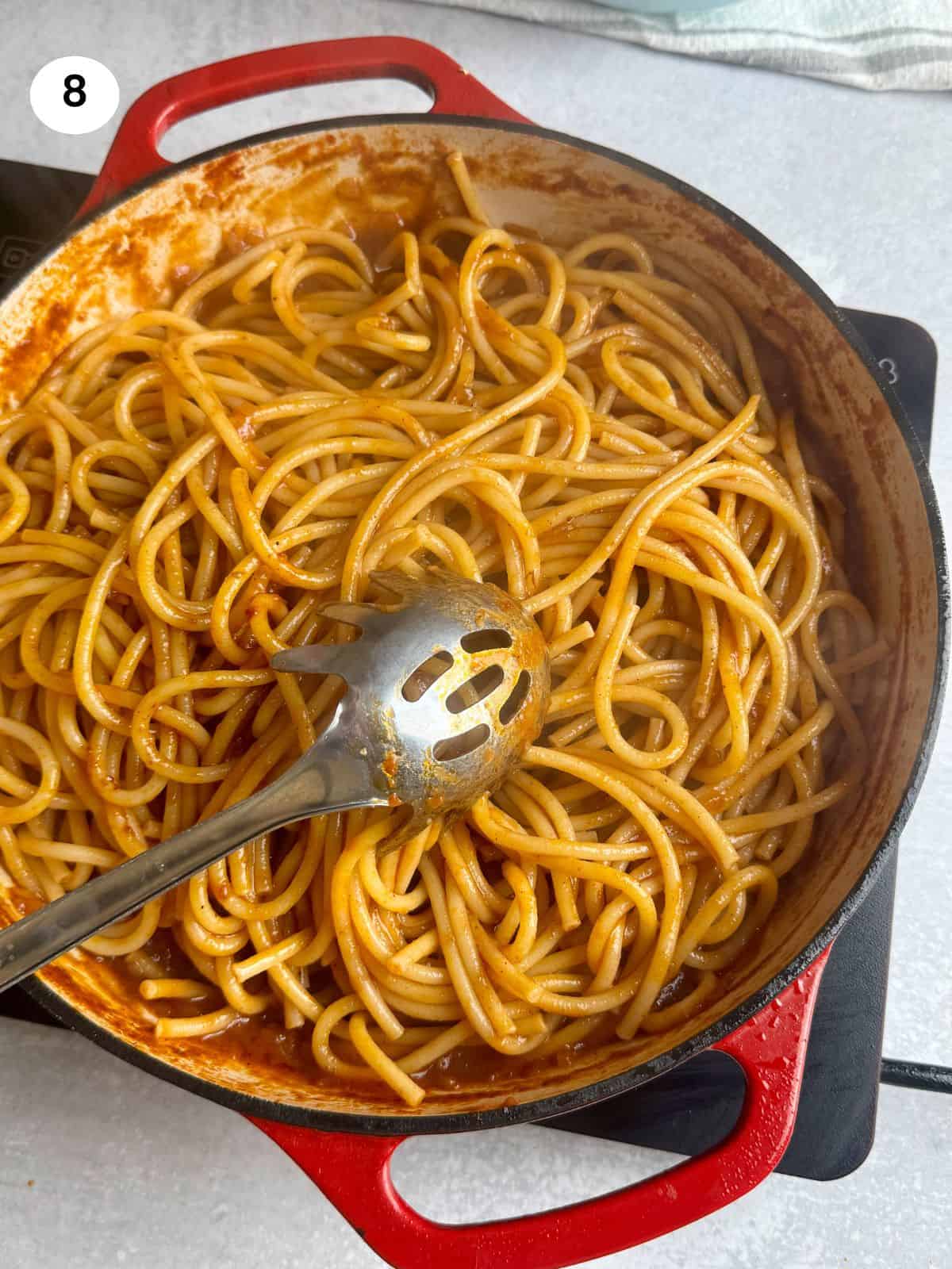 Added the cooked pasta to the tomato sauce.