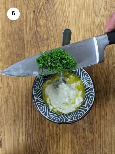 Adding the chopped dill into the dressing.