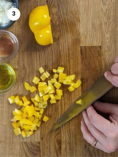 Cutting the bell pepper into cubes.