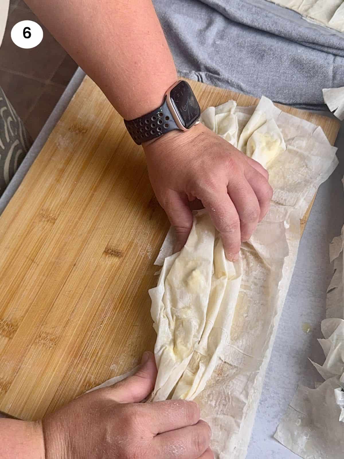 Folding the phyllo sheet like an accordion.