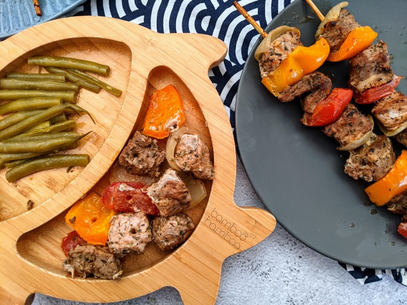 Serving pork skewers for toddler on a bamboo plate