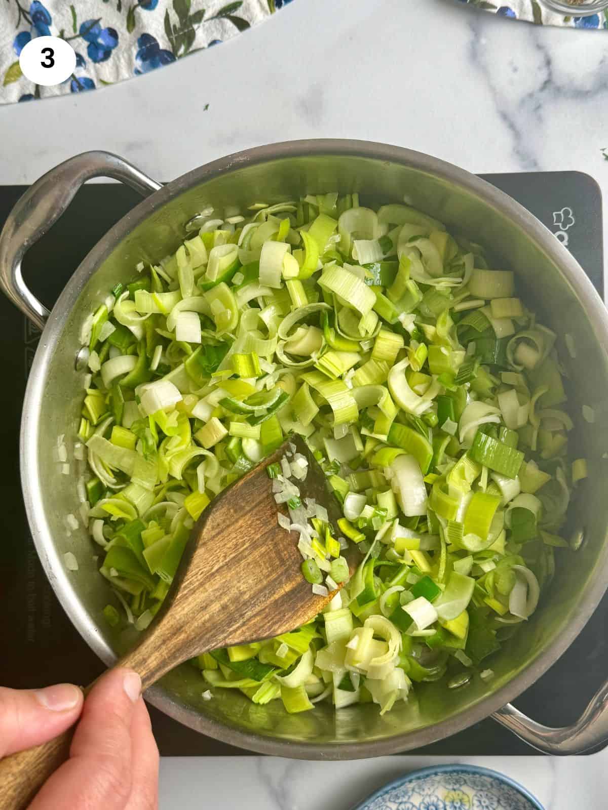 Mixing the leeks in the pot.